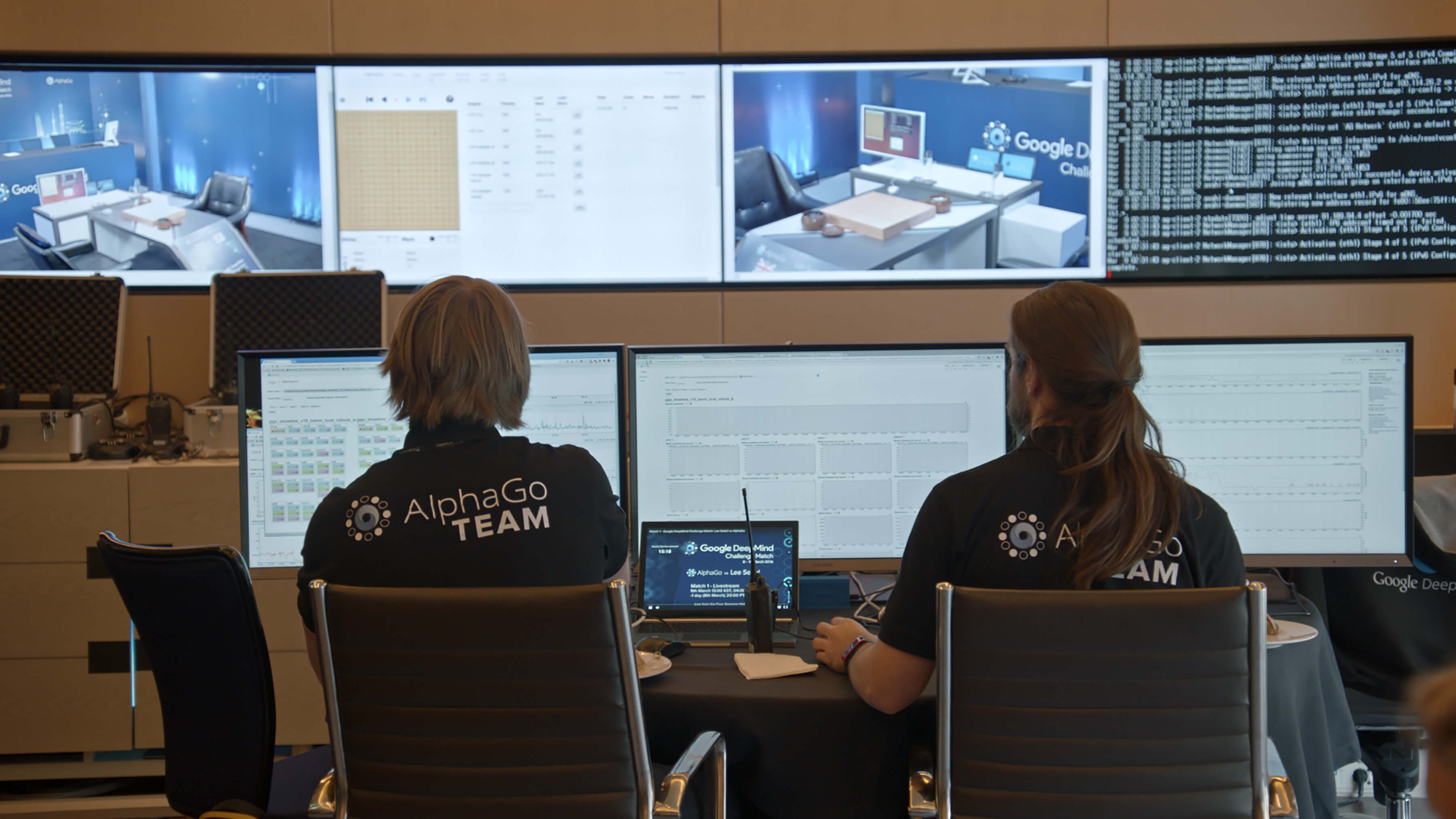 Two men sitting in front of video monitors